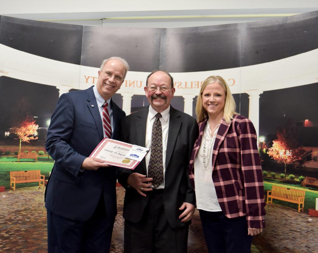 Joe Foster, center, receives a gift for his 35 years of service at Campbellsville University from Dr. Donna Hedgepath, provost and vice president for academic affairs, left, and Dr. Michael V. Carter, president. (CU Photo by Joshua Williams)