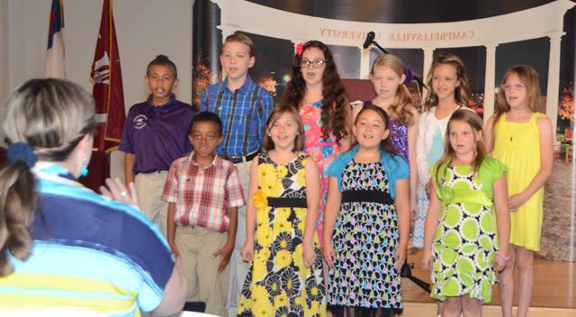 Cyndi Crowder Chadwick, right, directs her 3rd grade Campbellsville Elementary School Choir at  the Excellence in Teaching Awards Ceremony. Students from left are: Front row -- Gracie Crews,  Brianna Davis, Leigh Hicks and Zamar Owens. Back row --  Alexis Wheeler, Brianna Hayes,  Whitney Frazier, Mary Russell, Wesley Reynolds and Ronin Smith. (Campbellsville University  Photo by Linda Waggener)