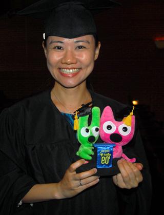 At left, Hsin-Jung Chang shows off a gift she received for earning her master of arts in music degree. (Campbellsville University Photo by Joan C. McKinney)  