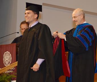 Matt Flanagan of Bardstown, Ky., son of Dan and Ginny Flanagan of Campbellsville, is hooded by Dr. John Hurtgen, dean of the School of Theology, as he receives his master of theology degree. (Campbellsville University Photo by Joan C. McKinney