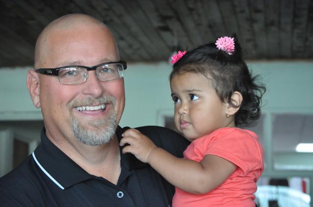 Rusty Hollingsworth, director of athletics at Campbellsville University, holds a child in Costa Rica on the recent coaches mission trip.