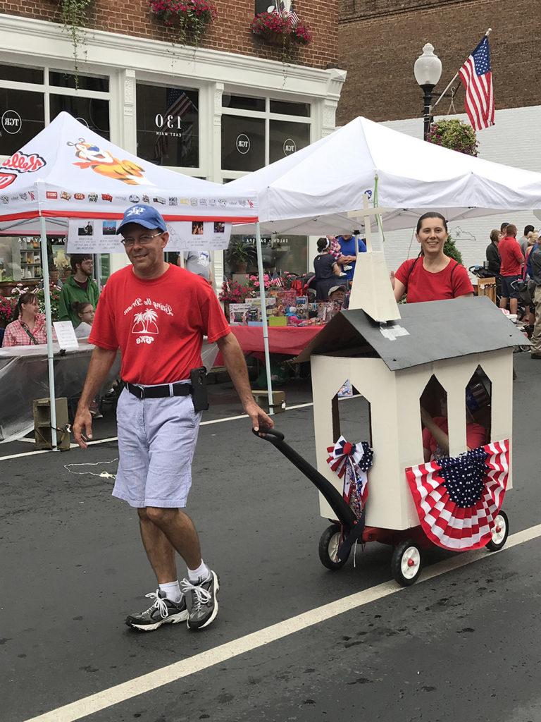 Rusty Watkins, dean of student services at Campbellsville University, pulls his son, Caleb, in the parade. Caleb won a first-place trophy in the children’s category. Caleb was supposed to be in the Children’s Parade, which got canceled due to rain, so Caleb got to ride in the “big” parade. His mom, Megan, is helping pull the “church.” (Campbellsville University Photo by Joan C. McKinney)