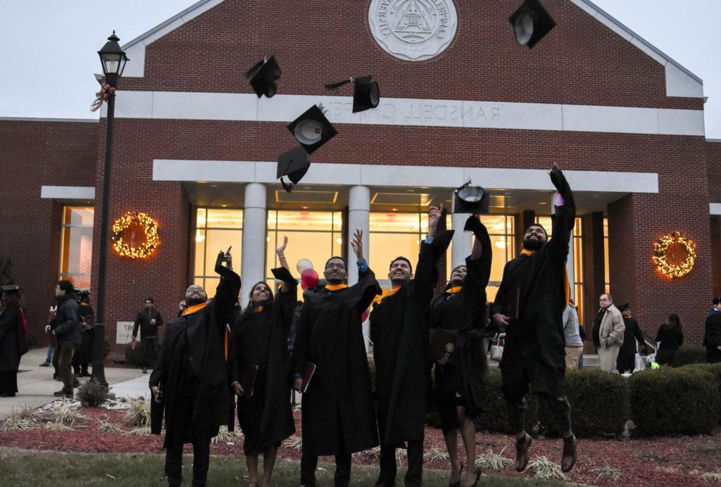 From left, Amar Basawaraju, Rashmitha Tallapalli, Rajiv Pilla, Venkata Daggubati, Nazeer Sharjeel and Tripura Mandali, graduate students from India, throw their caps after commencement. (Campbellsville University Photo by Joshua Williams)