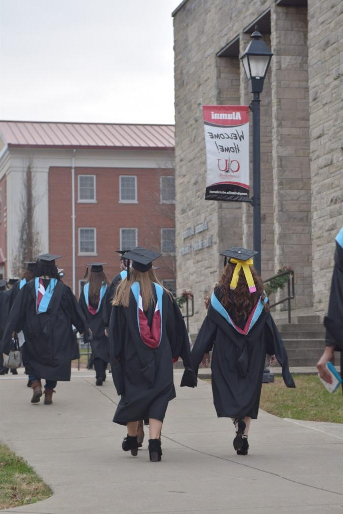 These graduates take their last walk from Davenport Student Commons to Ransdell Chapel before their commencement ceremony. (Campbellsville University Photo by Andrea Burnside)